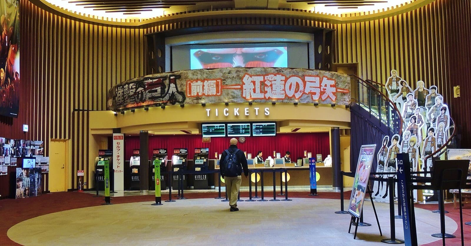 Interior of a Japanese multiplex cinema lobby with ticket counters and a moviegoer