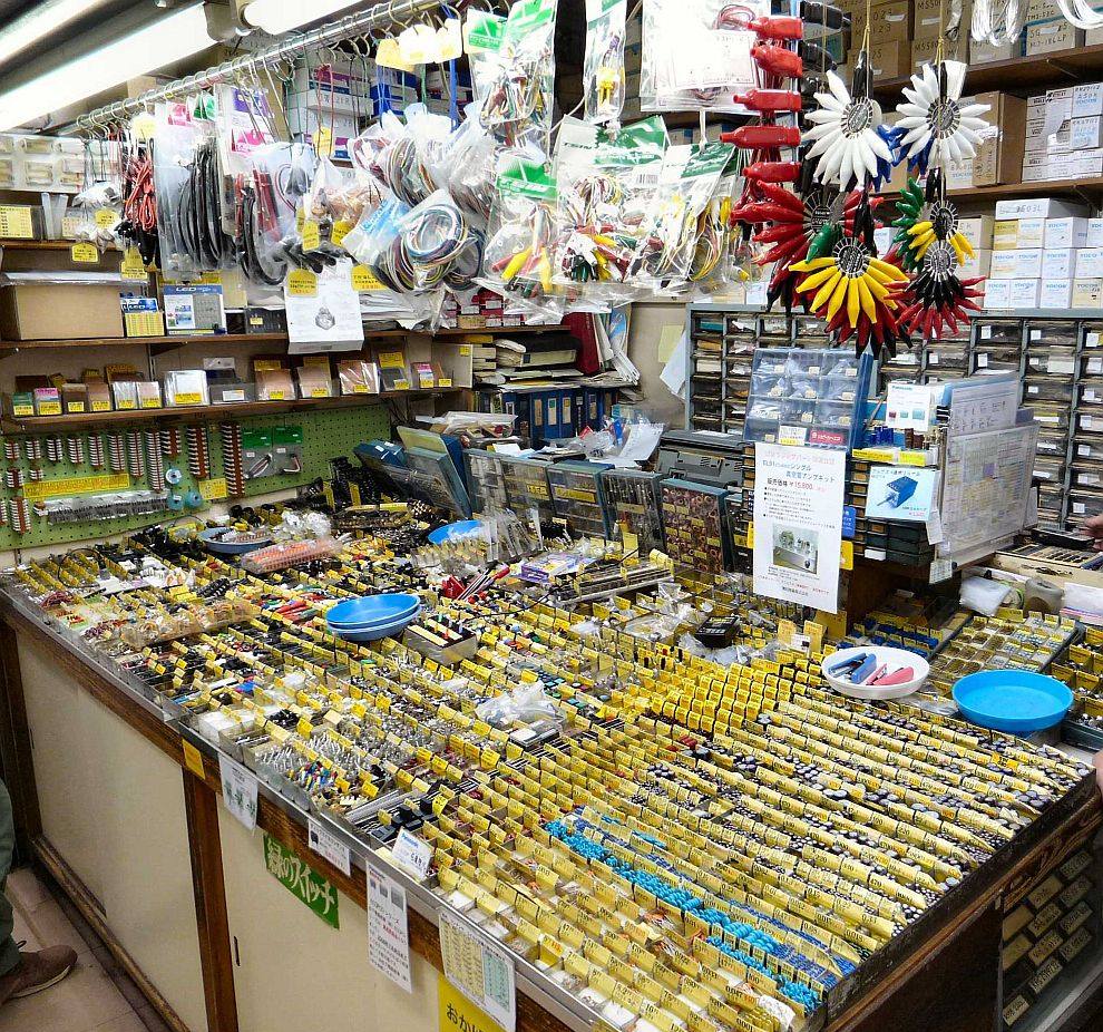 Counter of a cramped Akihabara shop stacked with bins of electronic components