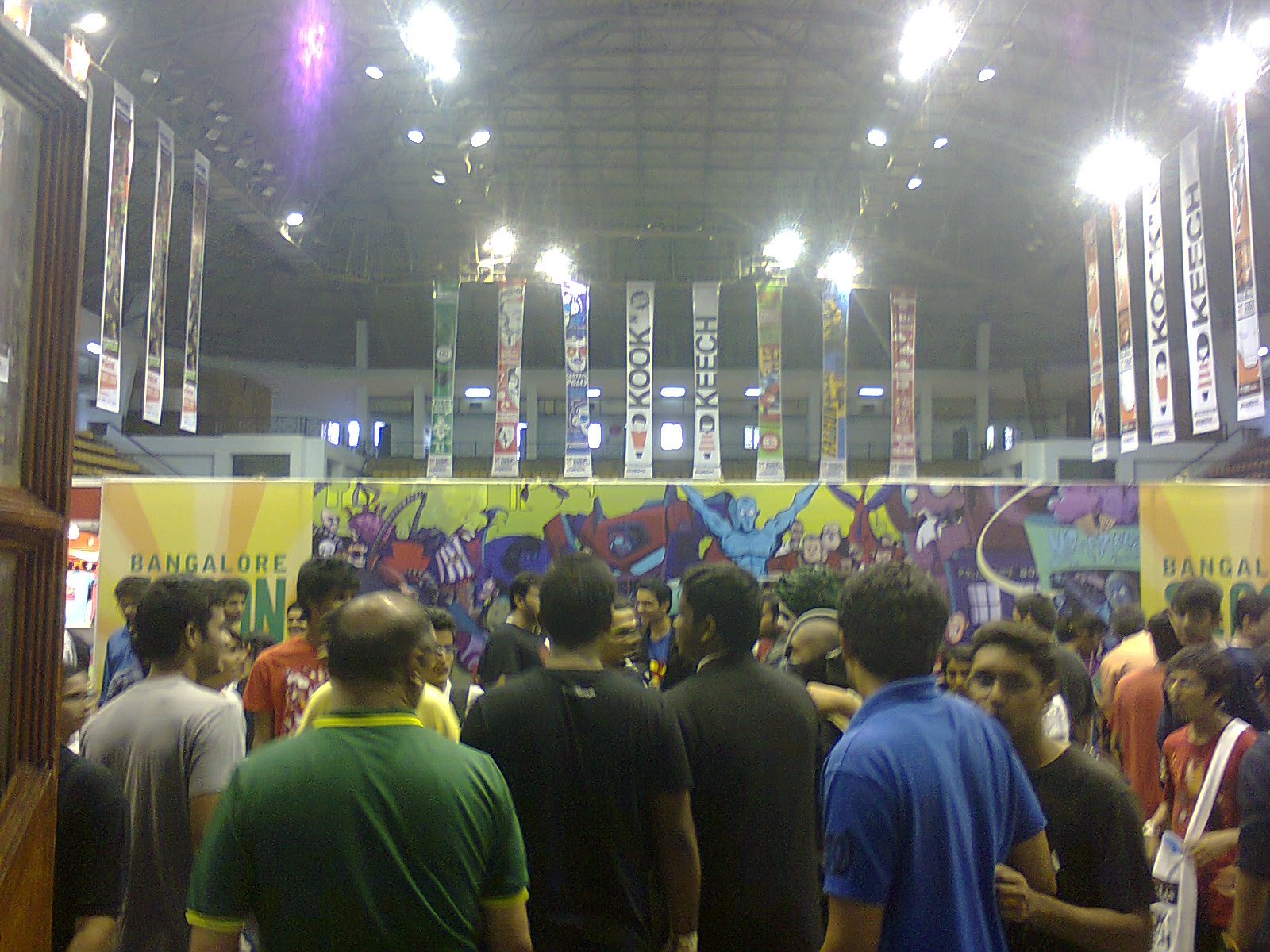 Crowded convention hall with Bangalore Comic Con banners hanging from the ceiling