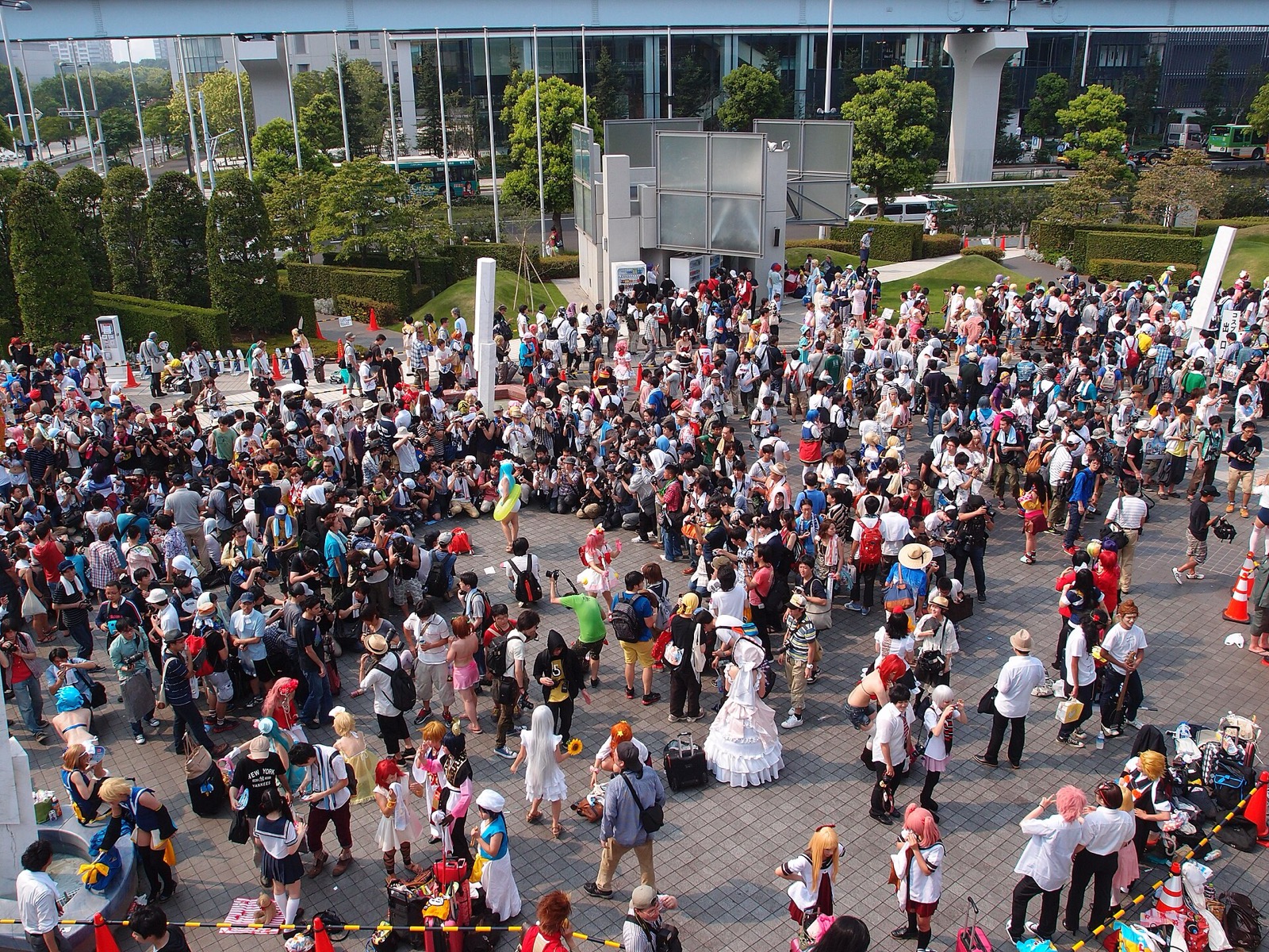 Aerial view of a dense outdoor crowd with costumed cosplayers posing for photos