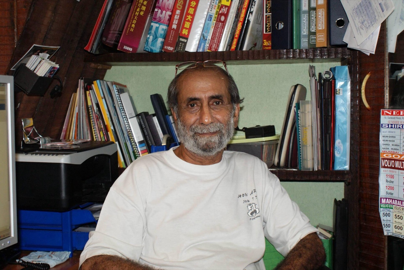 Aabid Surti seated at his desk in front of bookshelves