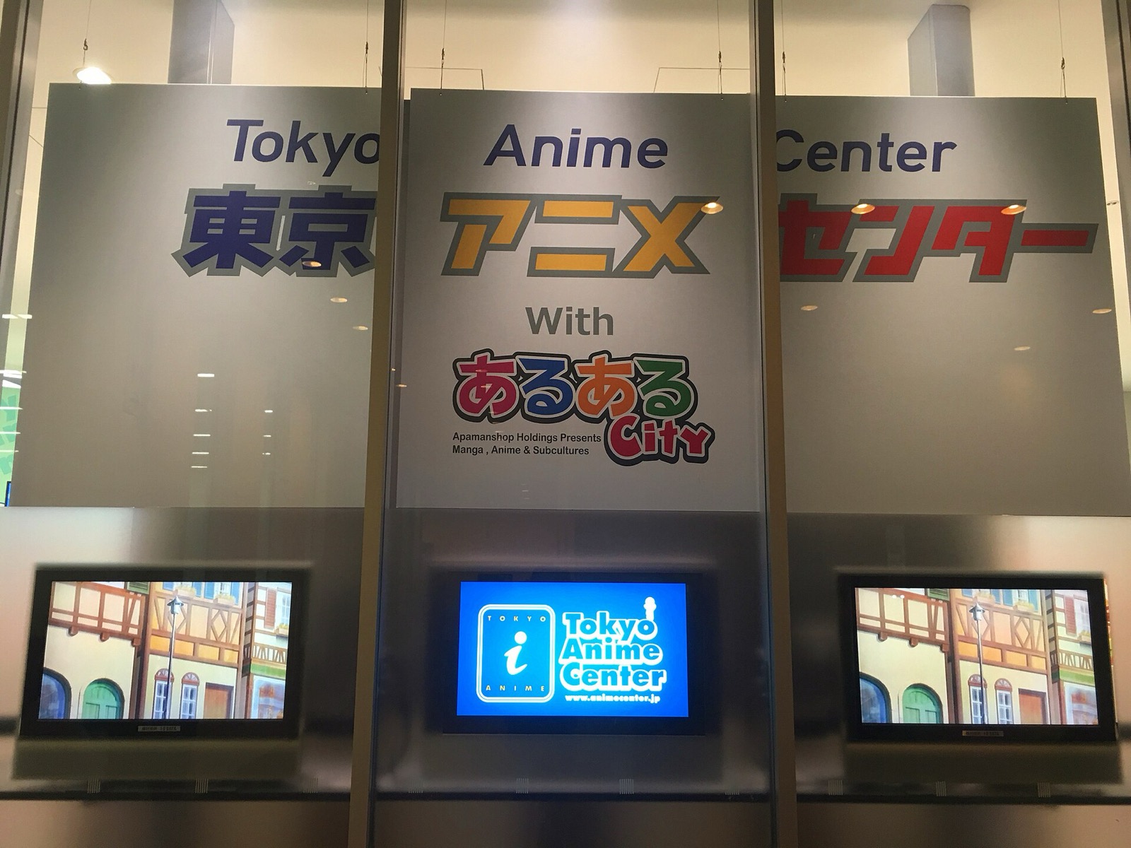 Signboards reading Tokyo Anime Center in English and Japanese above display screens