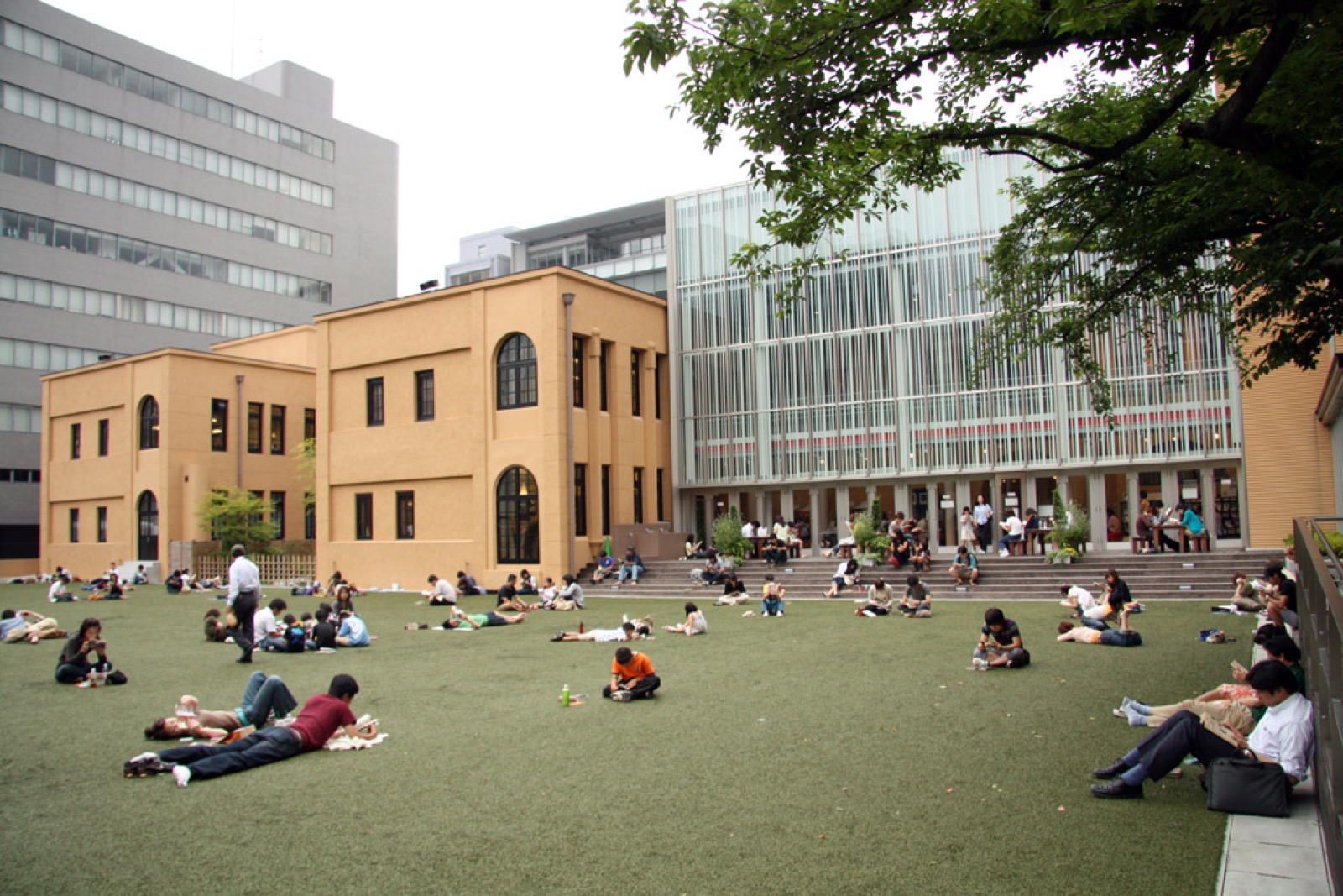 People sitting and reading manga on the lawn outside the museum
