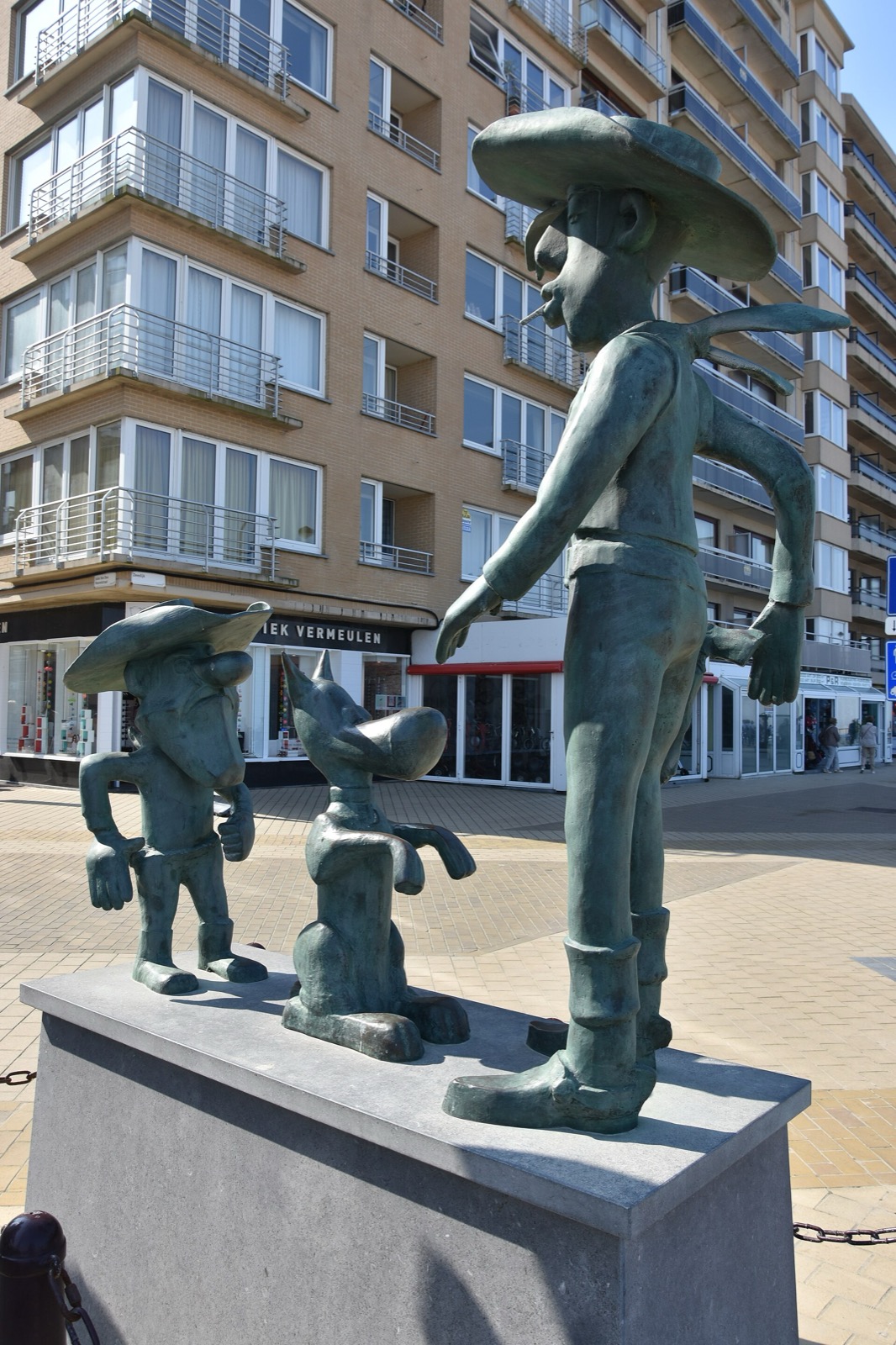 Bronze statue of Lucky Luke with a Dalton and Rantanplan on a seaside street
