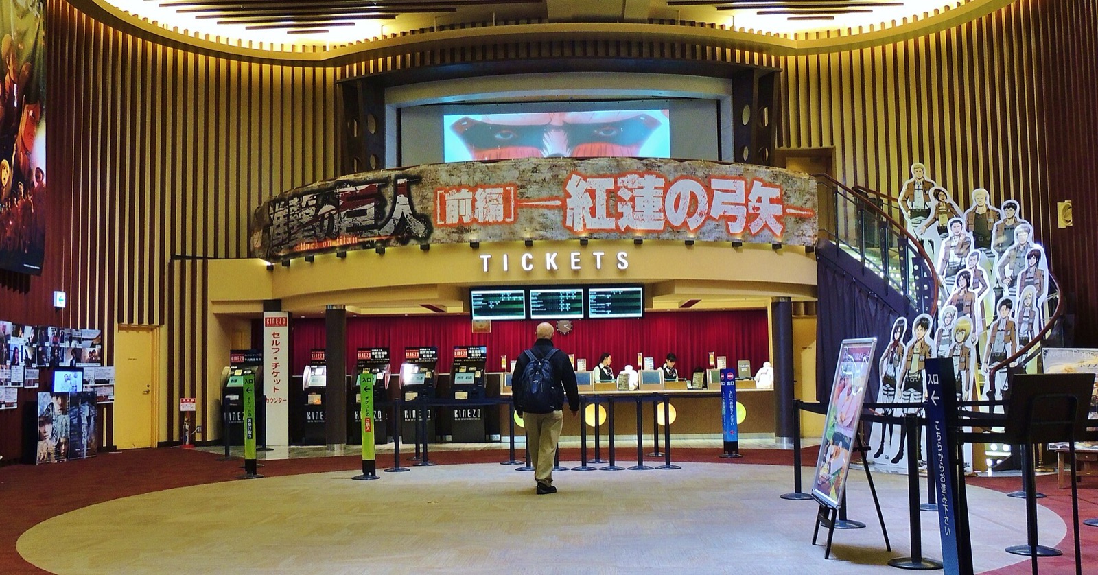 Interior of a Japanese multiplex cinema lobby with ticket counters and a moviegoer