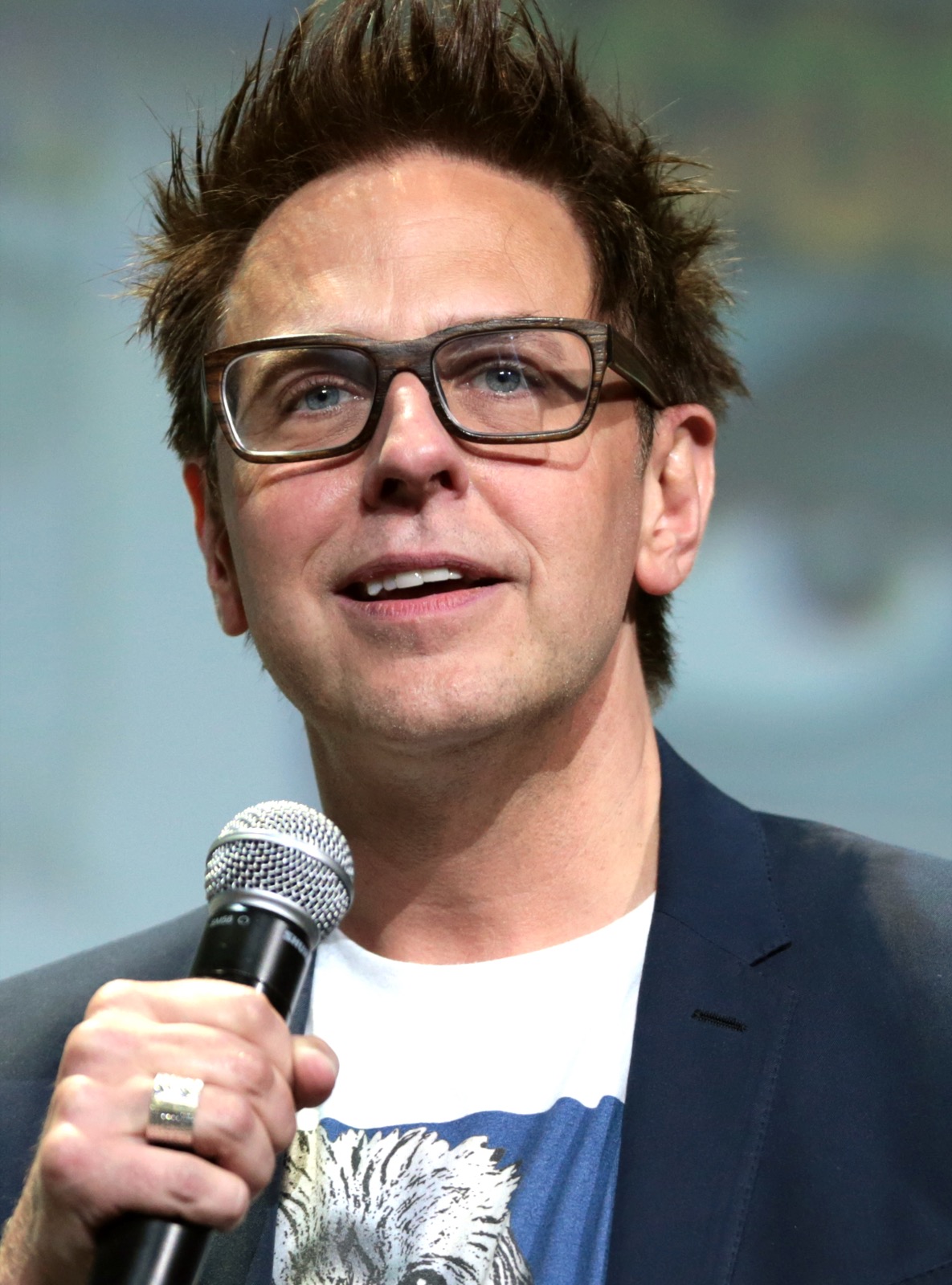 James Gunn speaking into a microphone at a panel