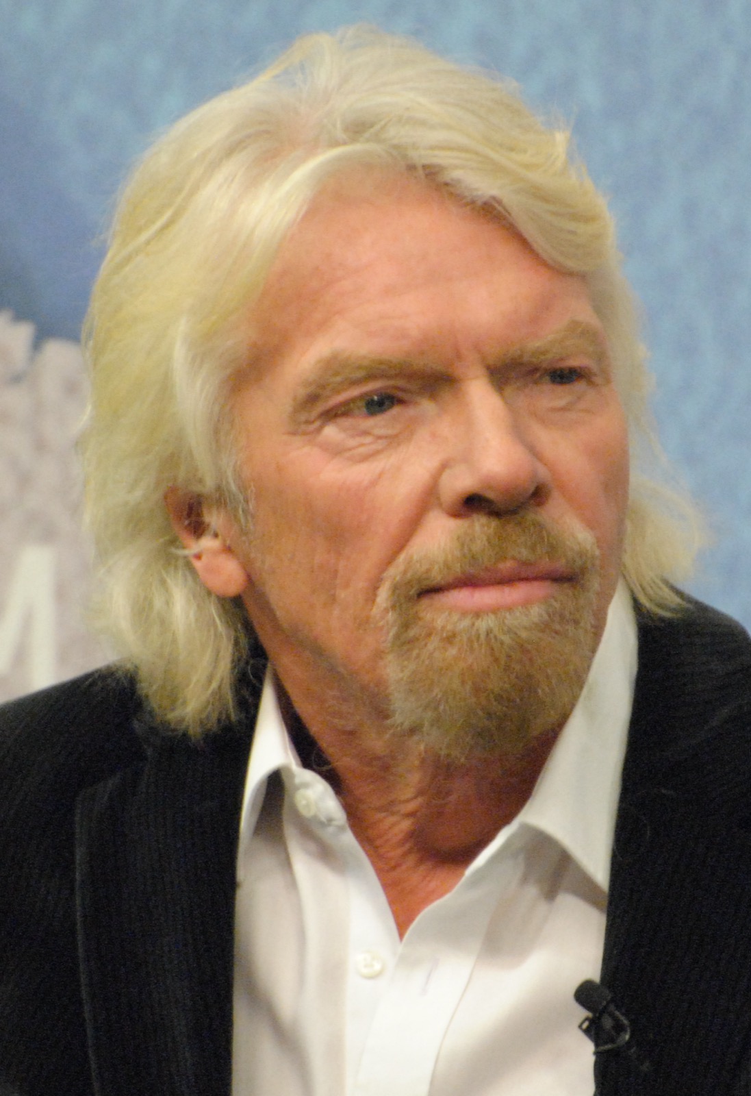 Portrait of Richard Branson in a dark jacket and open white shirt