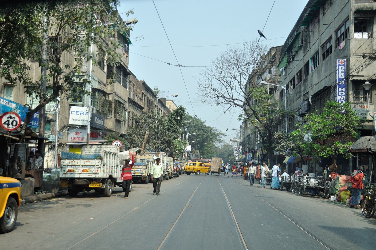 College Street in Kolkata with tram tracks, a yellow taxi and roadside stalls