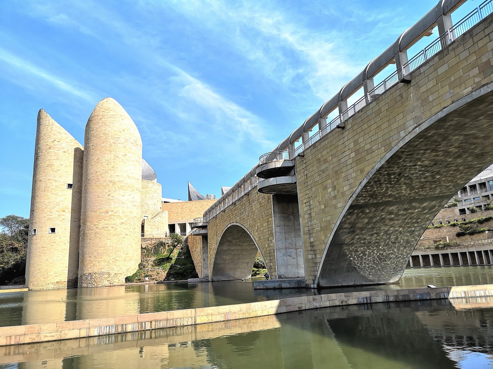 Sandstone towers and arched bridge of the Virasat-e-Khalsa museum over water