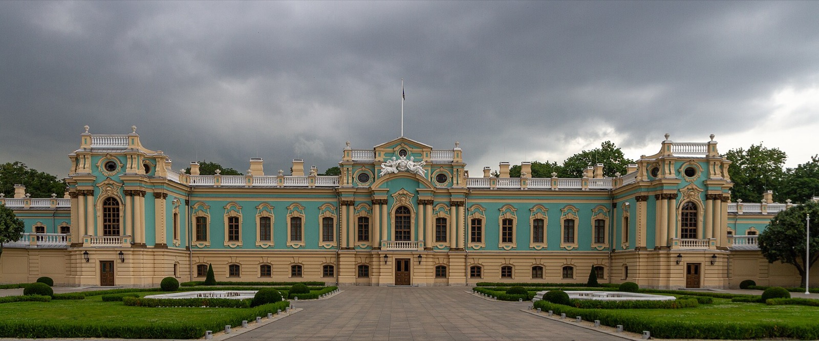 Wide view of the turquoise and cream baroque facade of the Mariinskyi Palace in Kyiv
