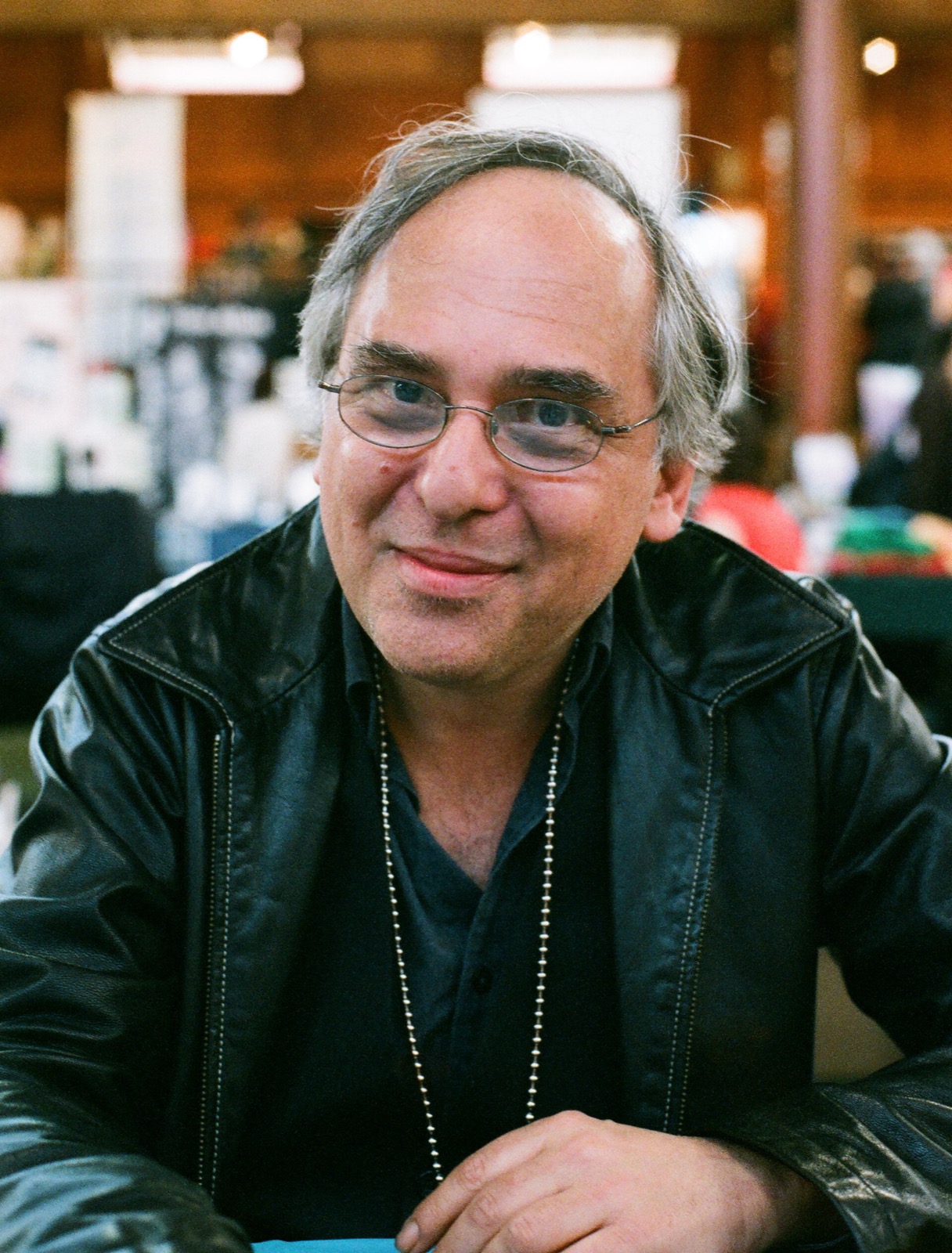 Art Spiegelman in glasses and a leather jacket, smiling at a comics expo