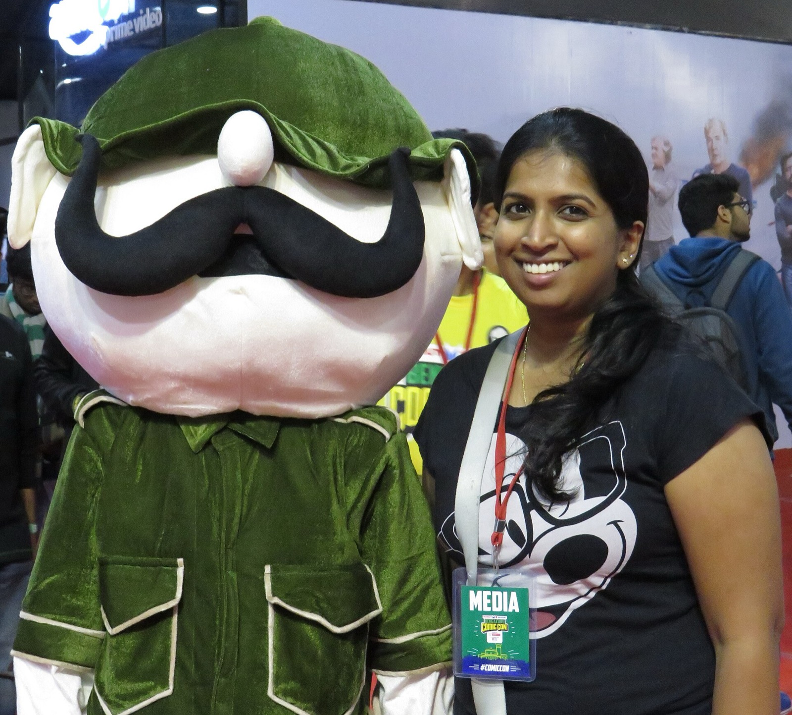 Person in a Shikari Shambu mascot costume posing with a smiling visitor